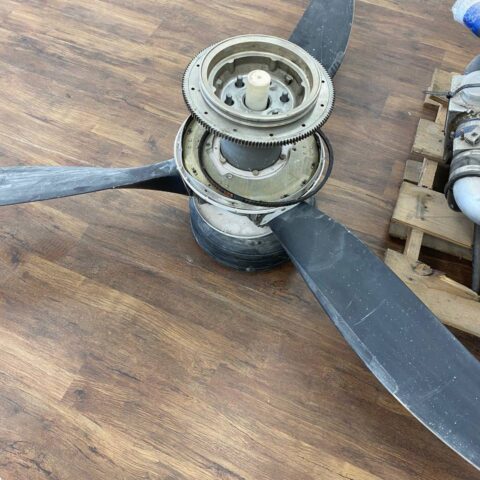 A propeller sitting on top of a wooden table.